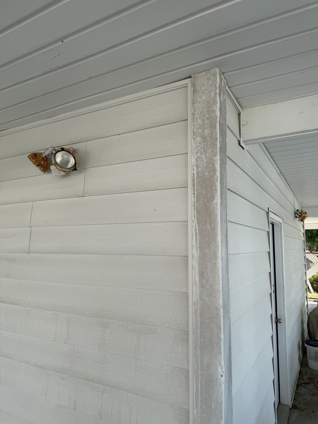 Foundation corner before soft washing — green algae and grime
