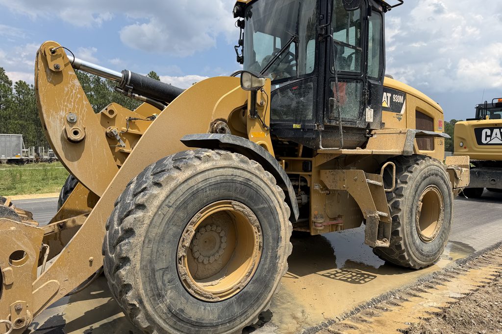 CAT wheel loader before washing — caked in job-site dust and grime