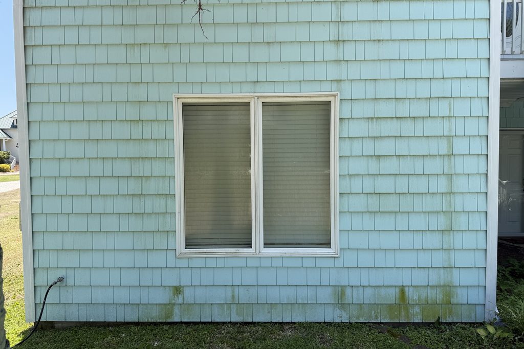 Coastal home shake siding before soft washing — heavy green algae staining